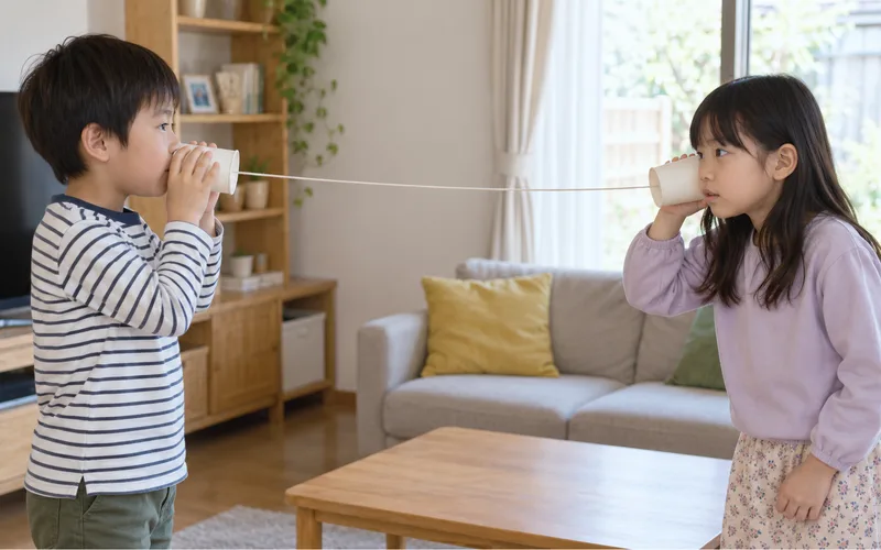 紙コップ糸電話で遊ぶ子ども